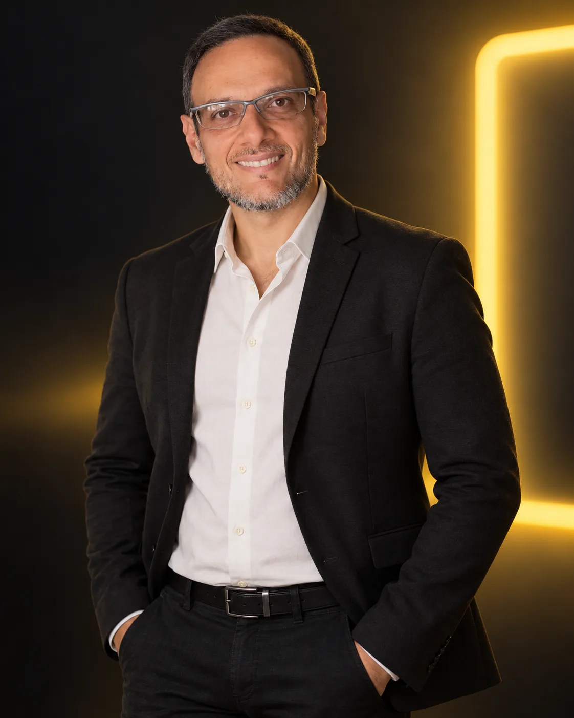 Fábio Pantoja, founder of Letreiro Digital, smiling in a dark suit in front of a yellow illuminated sign